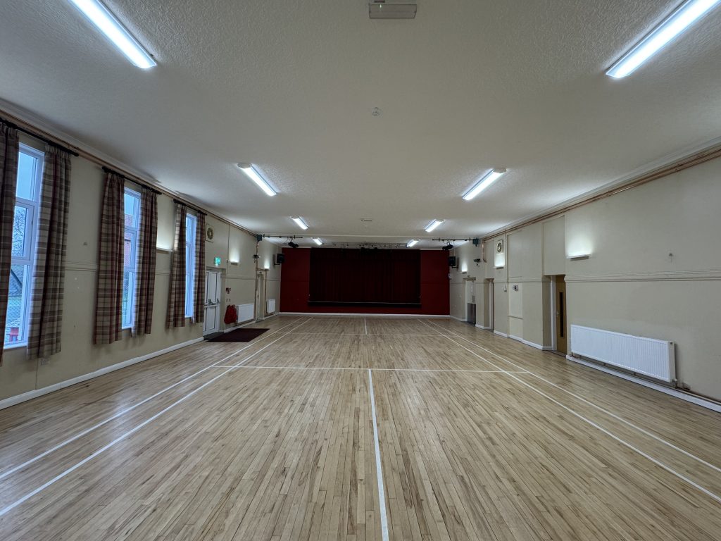A large hall with a wooden floor and stage
